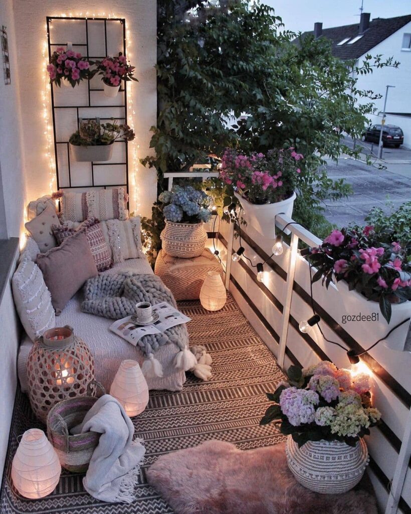 Cozy Evening Balcony with Warm Lighting and Lush Greenery

