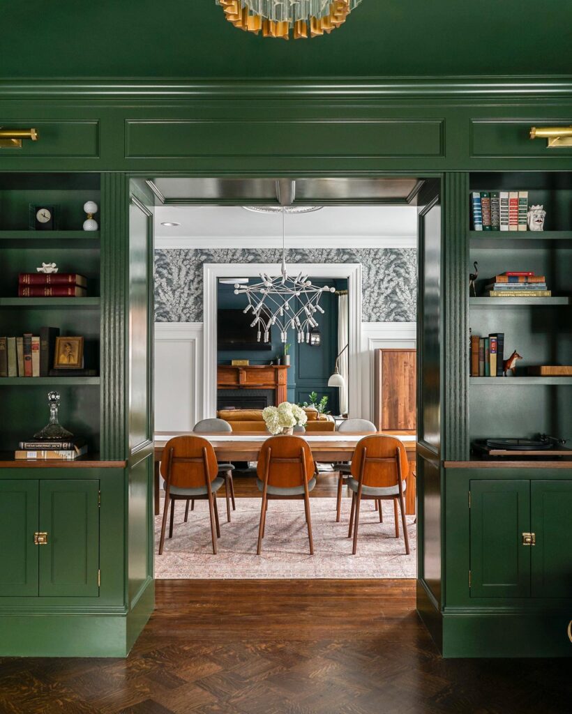 Elegant Green Dining Room Leading to a Modern Space

