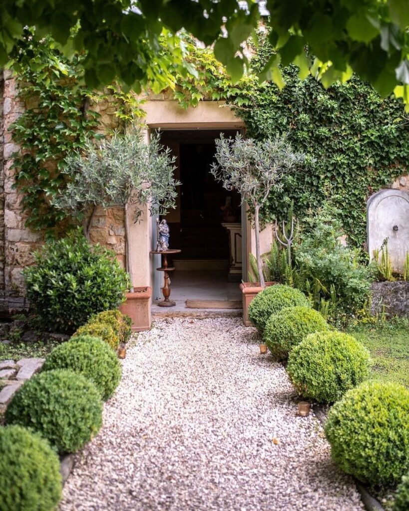 Charming Entrance with Gravel Path and Greenery
