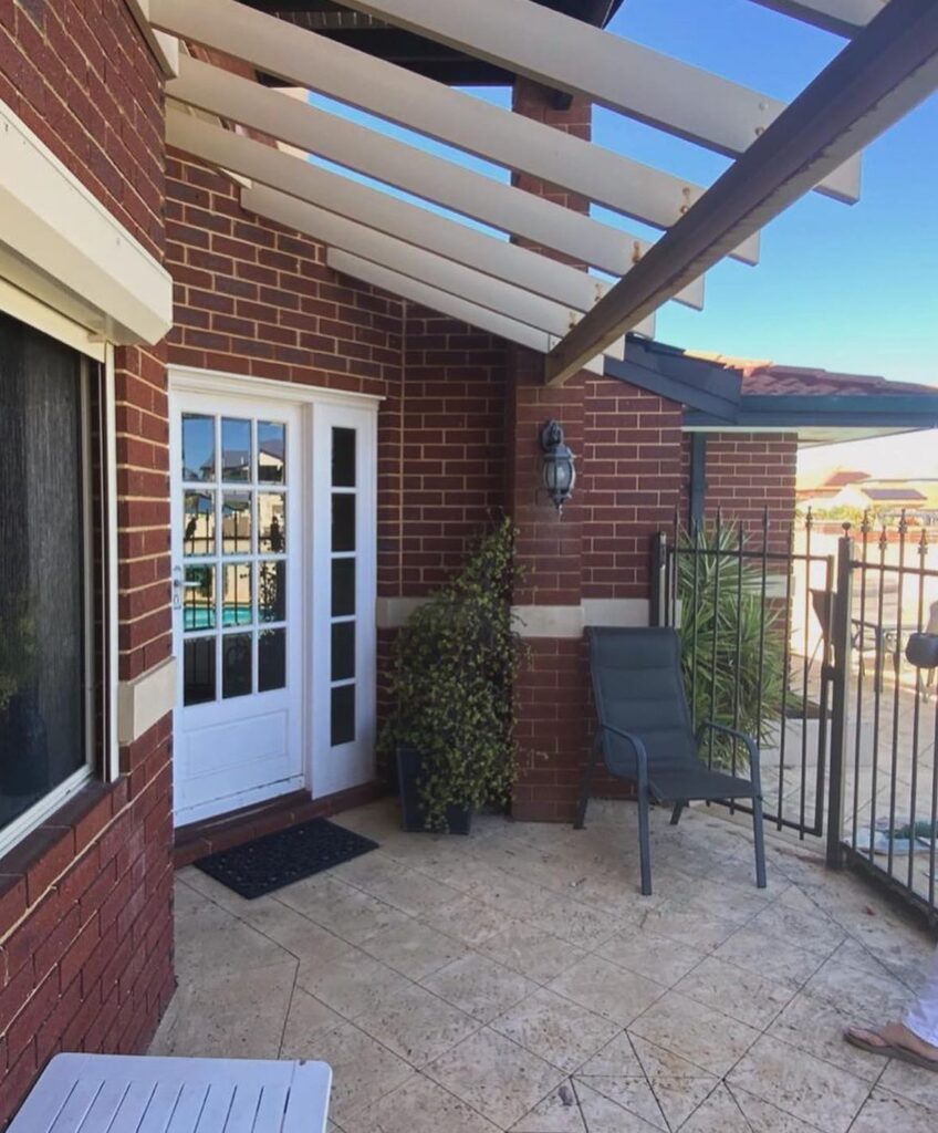 Red Brick House with Covered Patio and White Trim
