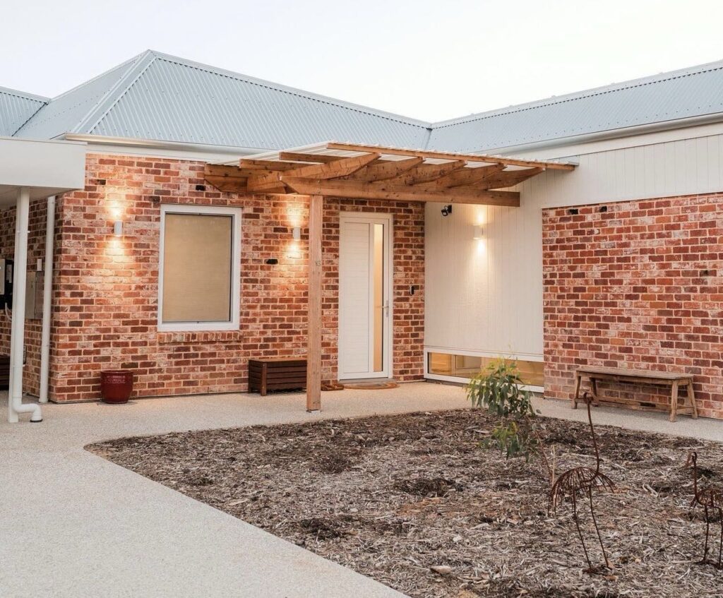 Rustic Charm A Brick Home with a Pergola Entrance
