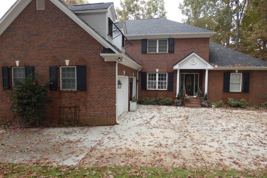 Traditional Red Brick Home with Black Shutters and Gray Roof
